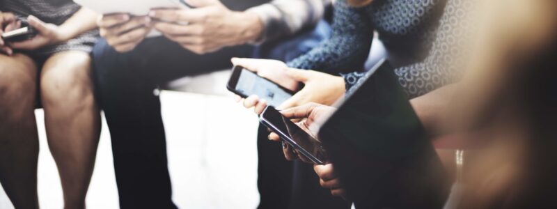 Employees using phones, tablets, laptops.