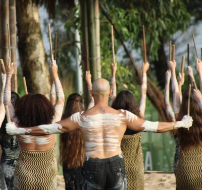 First Nations cultural dance outdoors with raised sticks