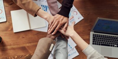 Employee hands on top of one another.