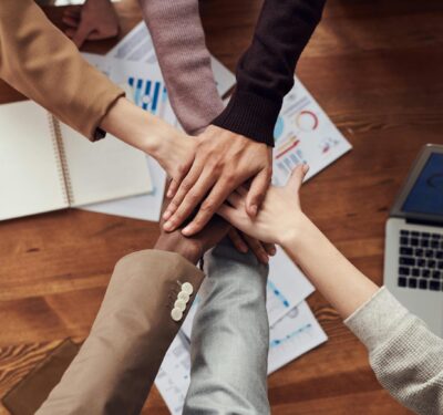 Employee hands on top of one another.