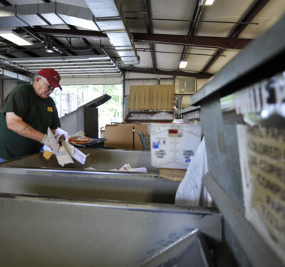Worker sorting paper at a recycling facility