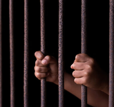 Hands gripping bars, symbolising modern slavery